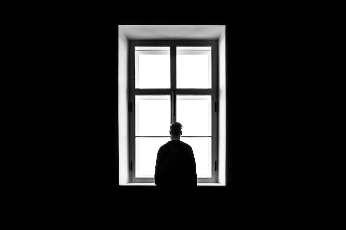 어두운 여름밤 창가에 앉아 잠들지 못하고 바깥을 바라보는 사람의 실루엣, 여름밤 잠 못 드는 사주에서 과한 화 기운으로 열이 식지 않는 모습을 떠올리게 하는 대표 이미지