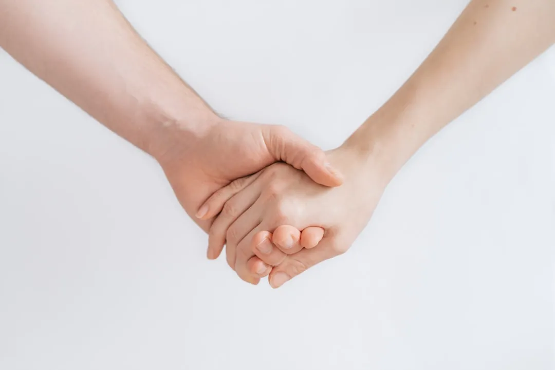 두 손을 맞잡아 서로를 보듬는 모습, 천의성이 상징하는 공감과 돌봄의 재능을 보여주는 이미지