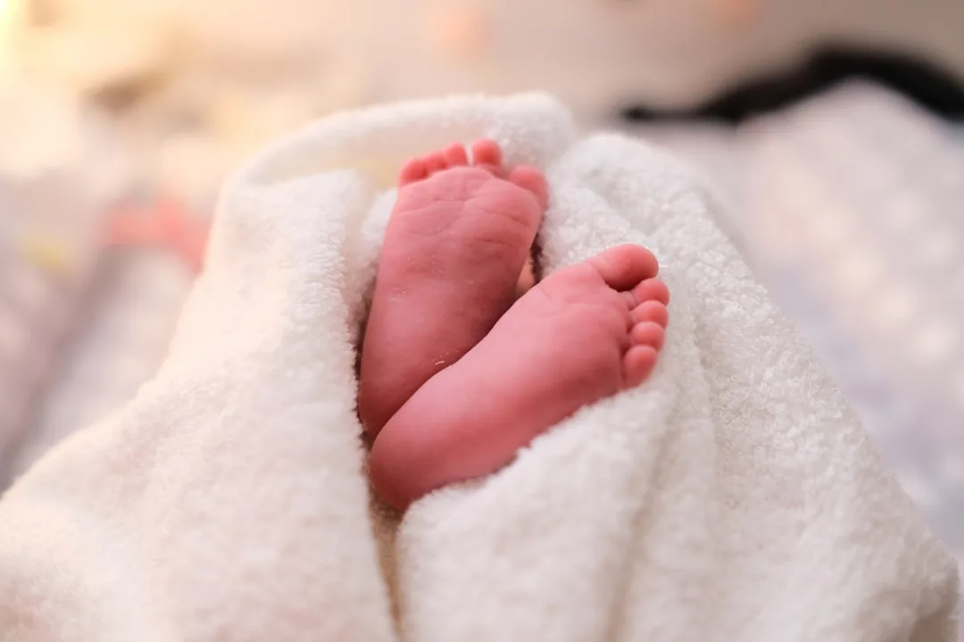 흰 포대기에 감싸인 갓 태어난 아기의 발, 평생 불릴 이름에 사주의 부족한 기운을 담아 주려는 자원오행 작명의 따뜻한 마음을 떠올리게 하는 이미지